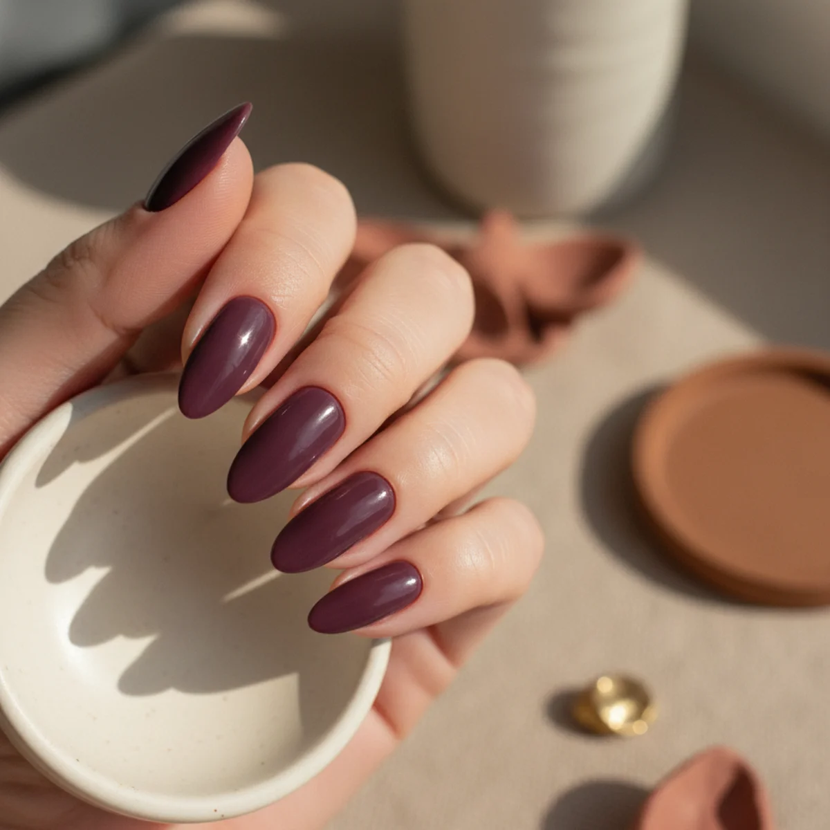 Almond nails in a deep plum with a soft matte velvet texture finish