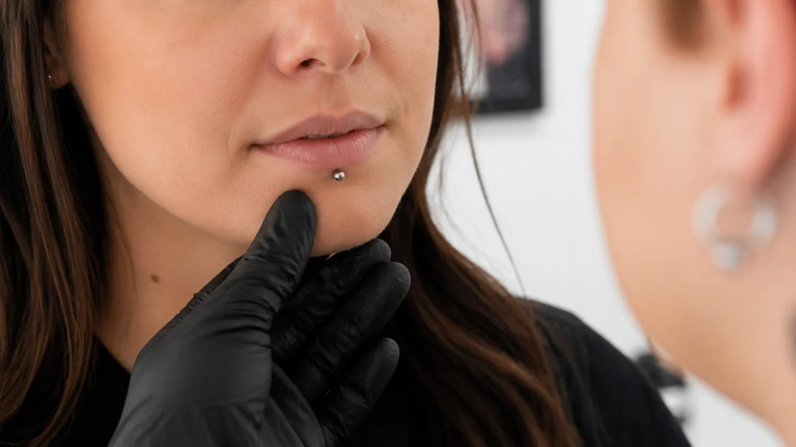 A person consulting a professional about a piercing concern