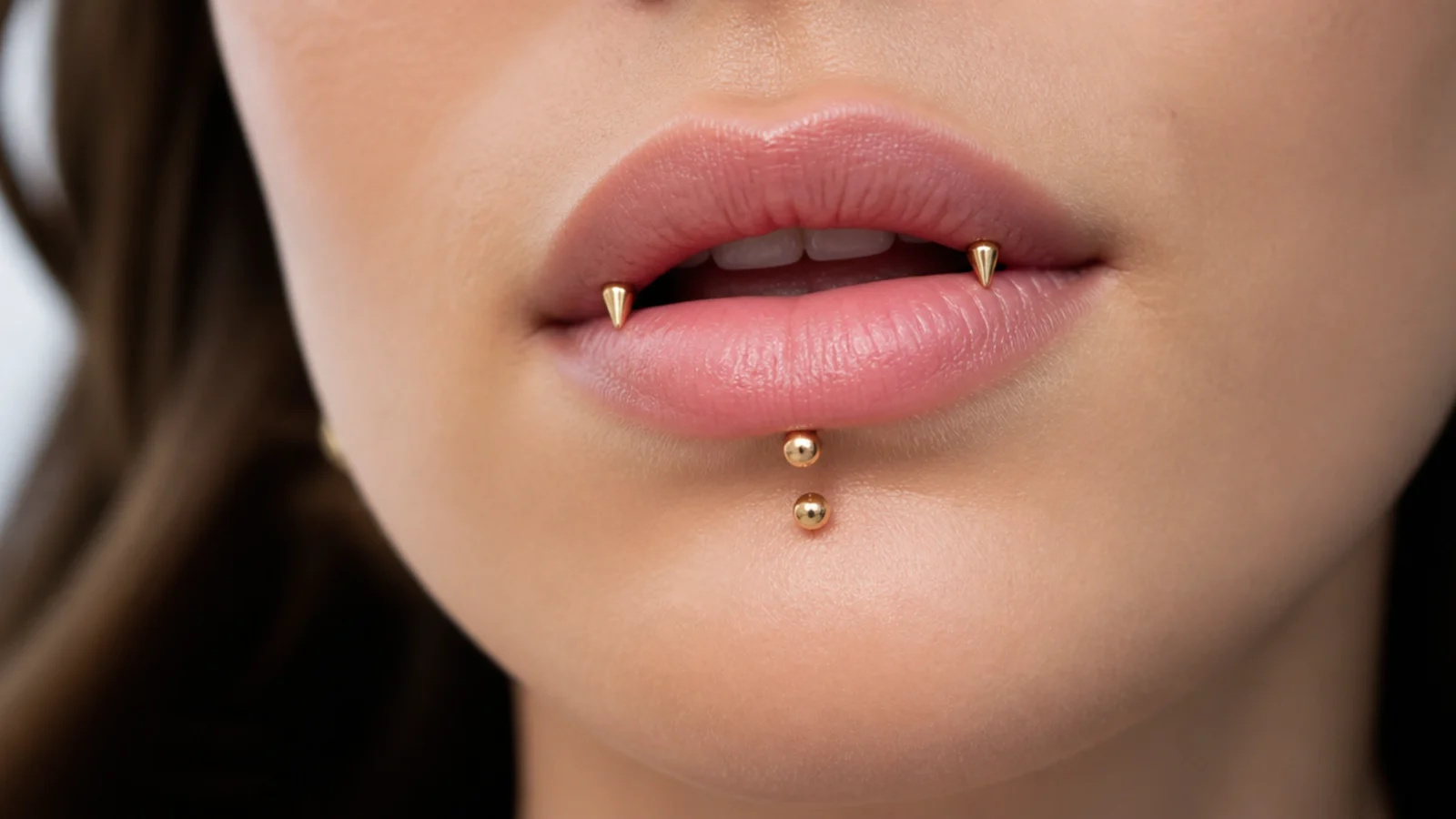 Angel fangs and vertical labret in high-shine gold