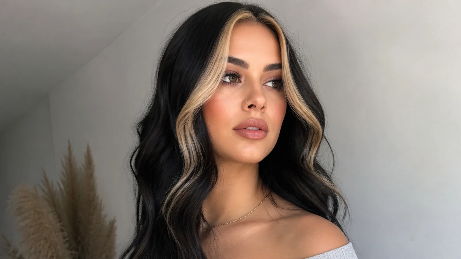 Black hair with a bold chunky blonde or caramel money piece
