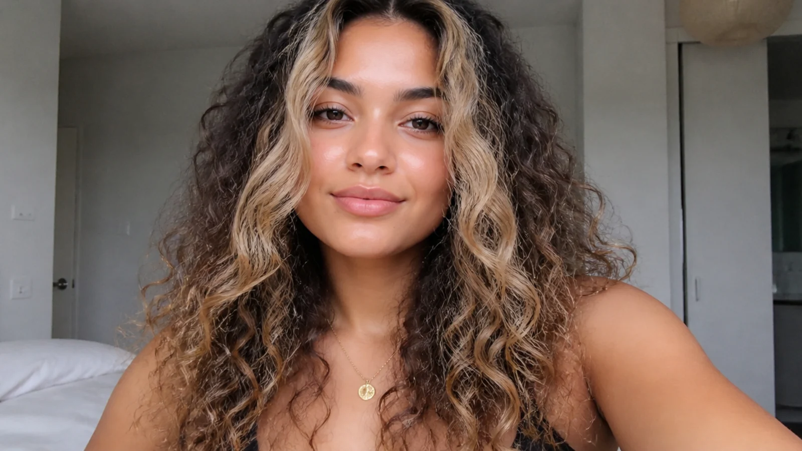 Curly hair with an ombre money piece lighter toward the ends