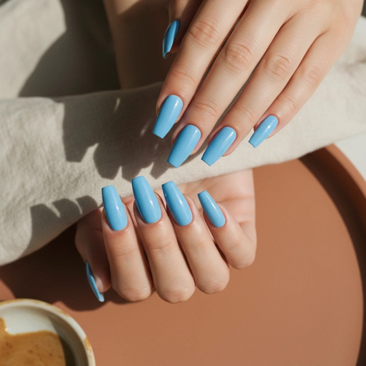 Long coffin nails in a bright clear sky blue on a pale background