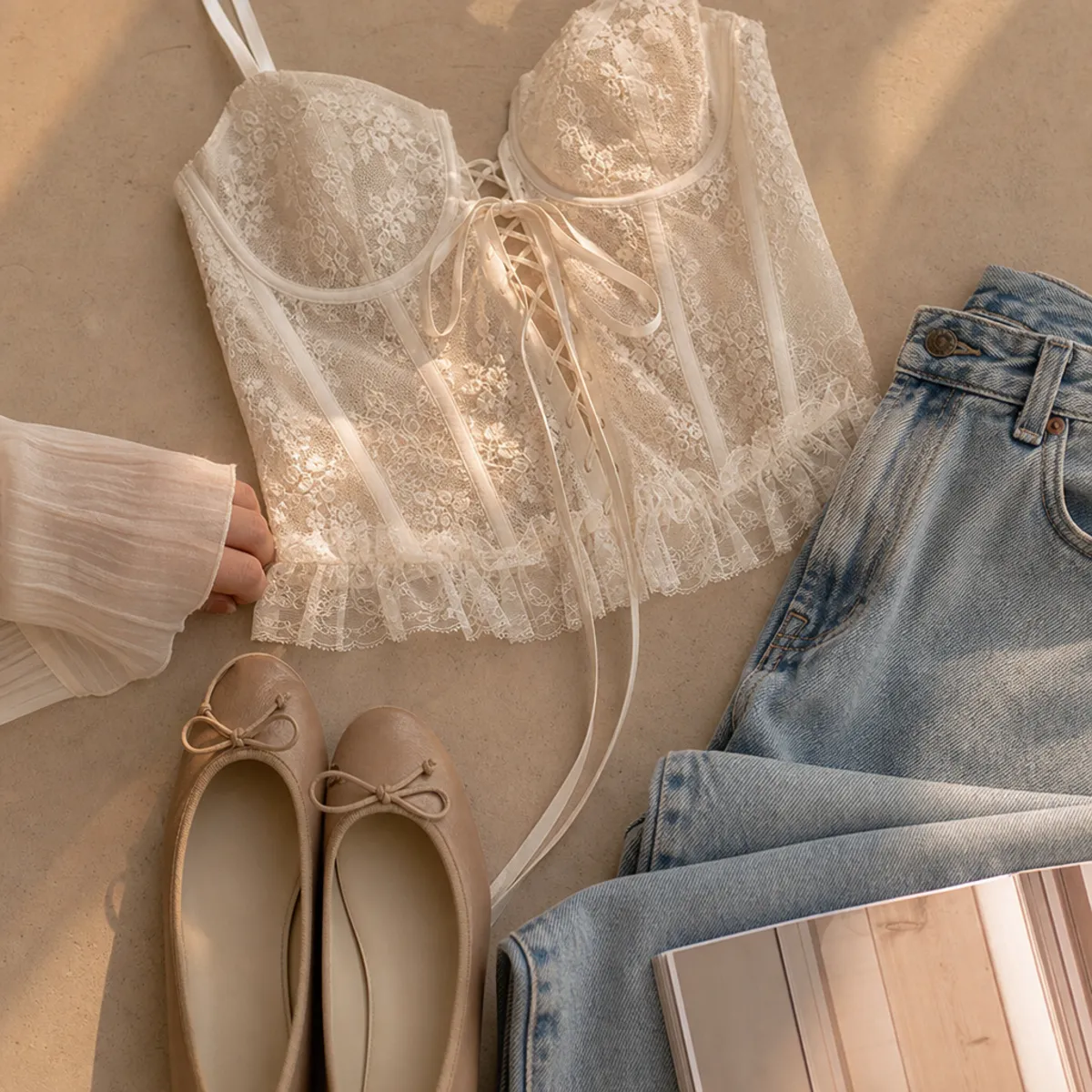 Faceless waist-up shot of a delicate lace corset with jeans and ballet flats