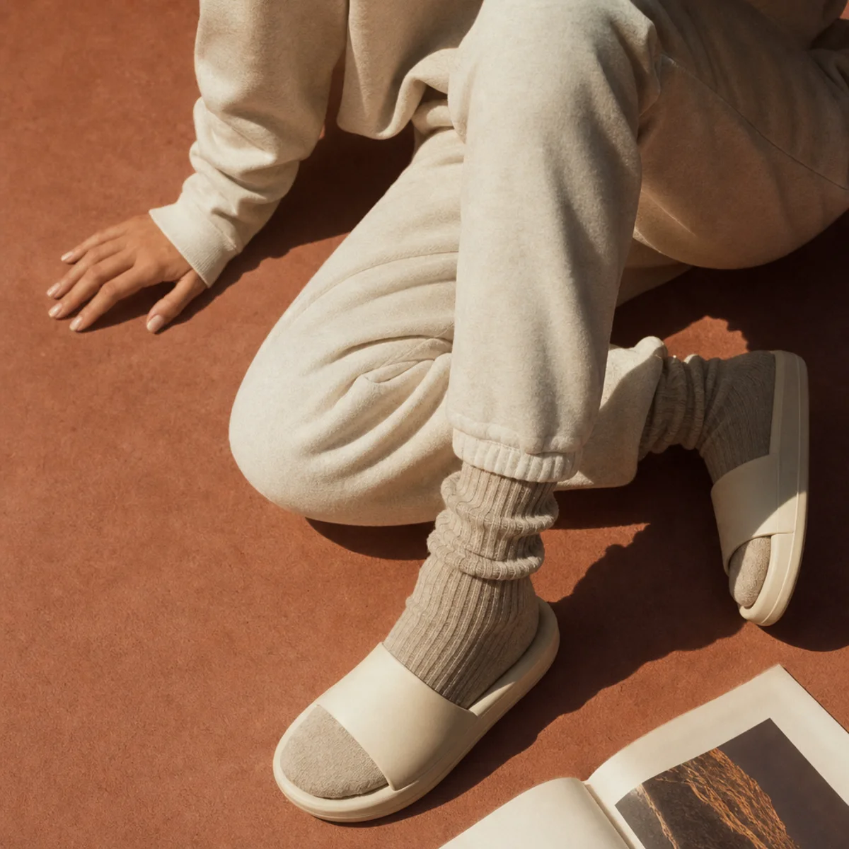 Faceless waist-down shot of soft sweatpants with chunky socks and slides