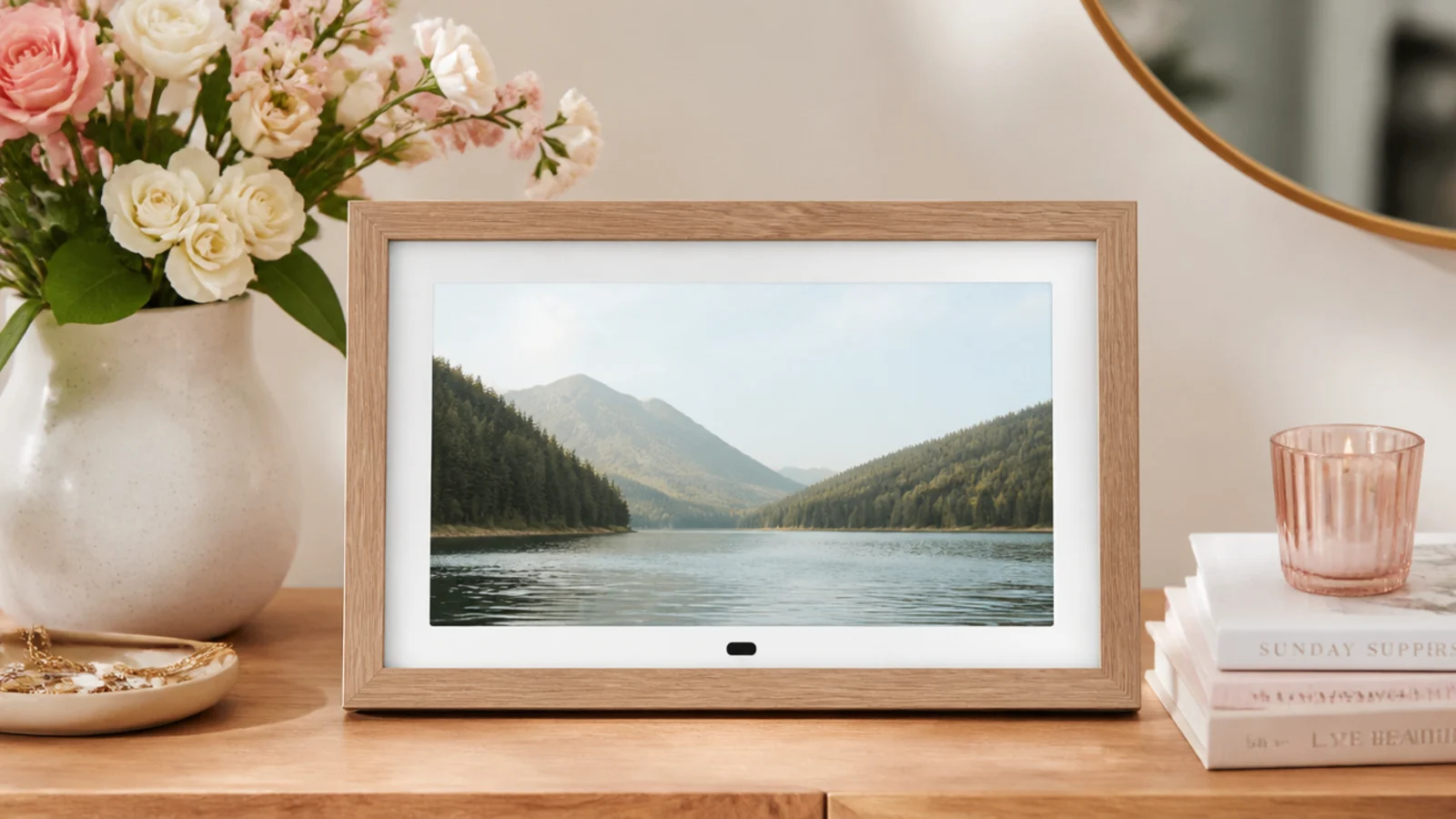 Faceless shot of a wood-framed digital photo display on a console table showing a landscape image