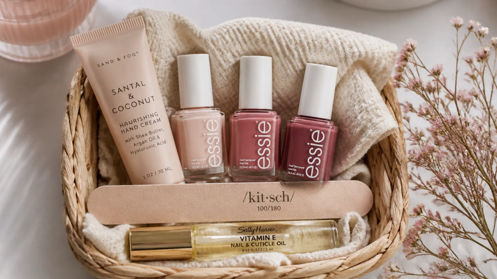 Faceless flat-lay of a nail care basket with polish bottles, a file, cuticle oil and hand cream