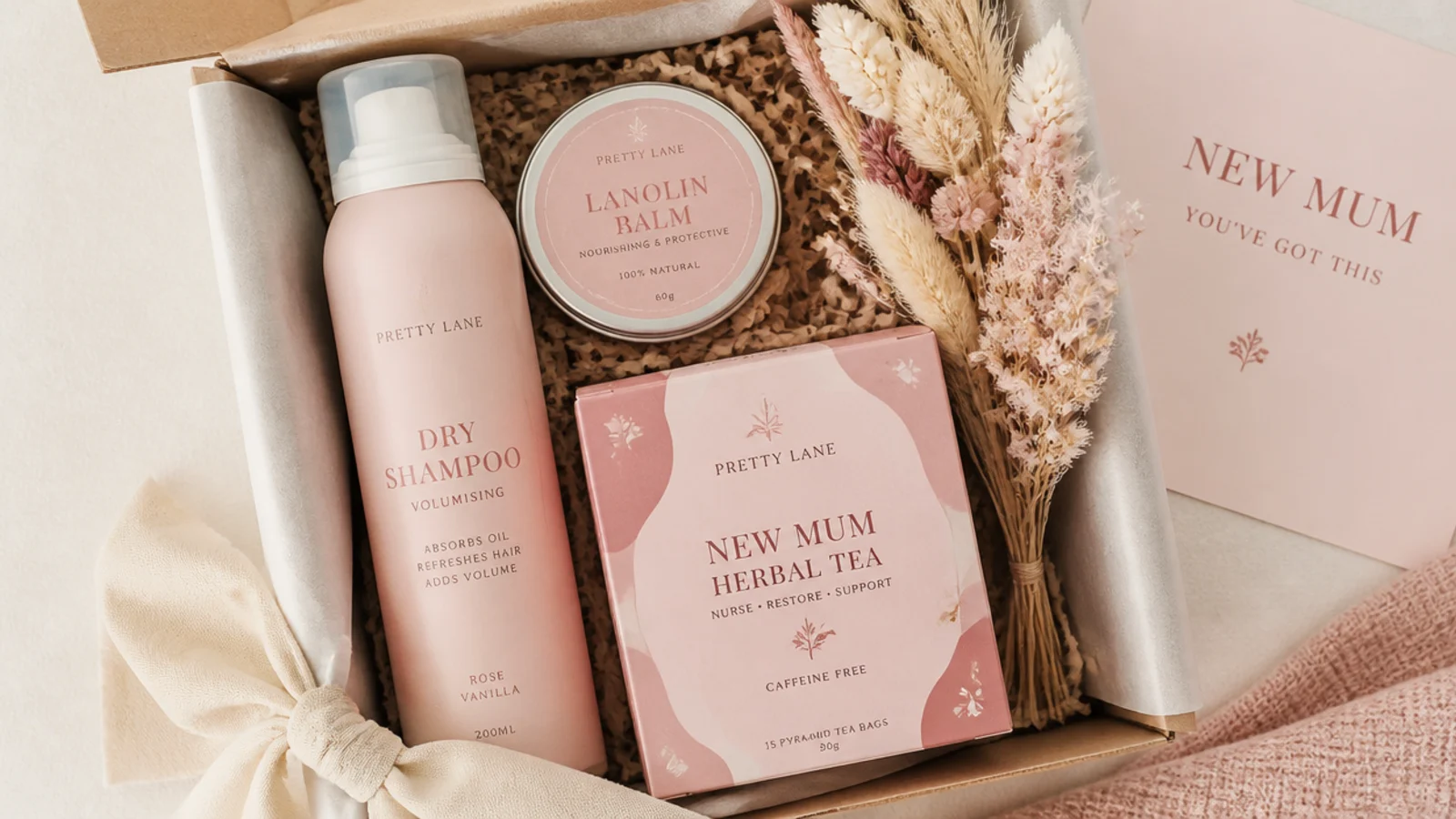 Faceless overhead shot of a new mum gift hamper with lanolin balm, dry shampoo and herbal tea