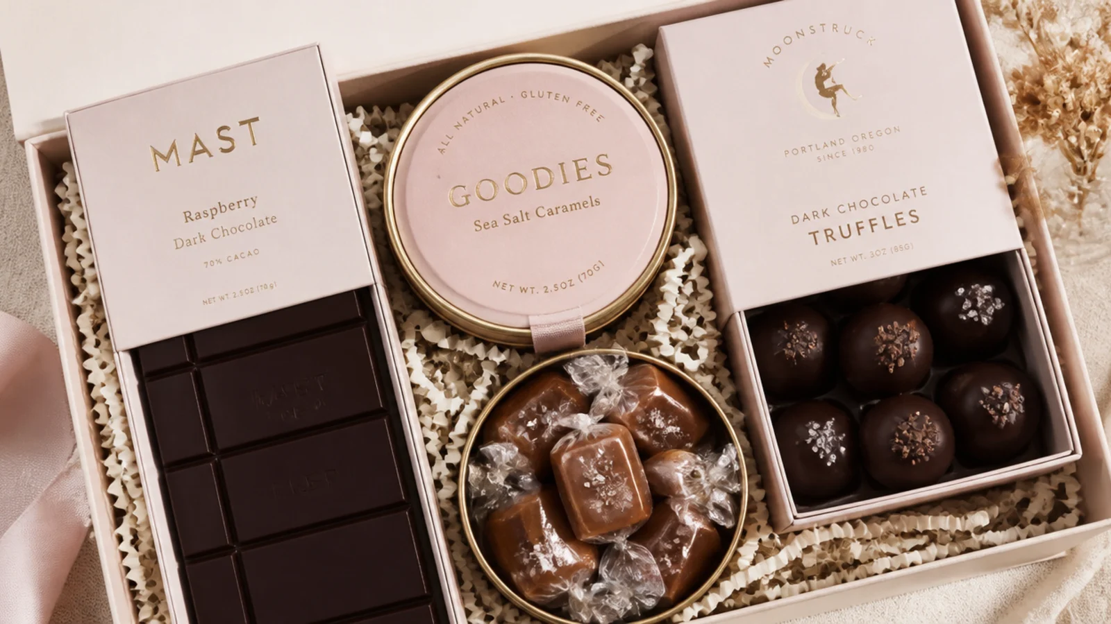 Faceless overhead shot of a chocolate lover gift hamper with dark bar, sea salt caramels and truffles