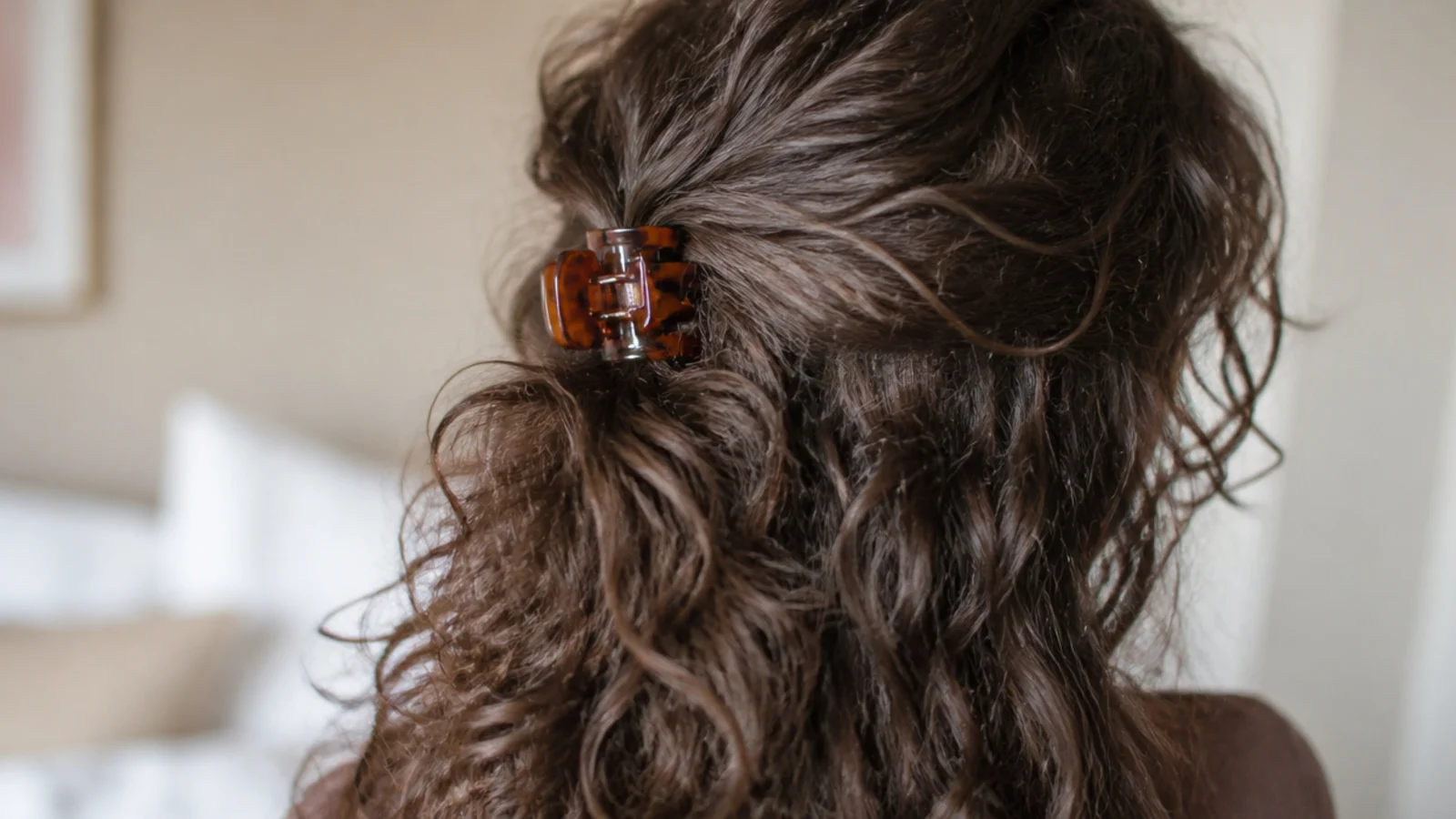 Second day frizzy curly hair in a half up style with pillow texture and loose crown volume