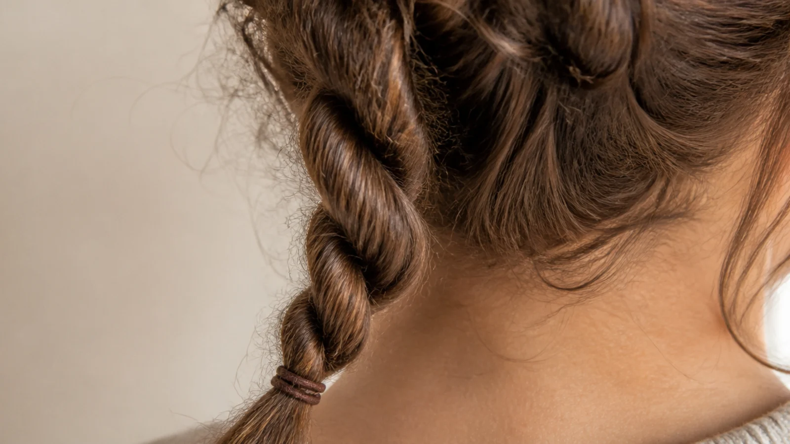 Two strand rope braid on frizzy hair twisted into a spiral rope and tied at the ends