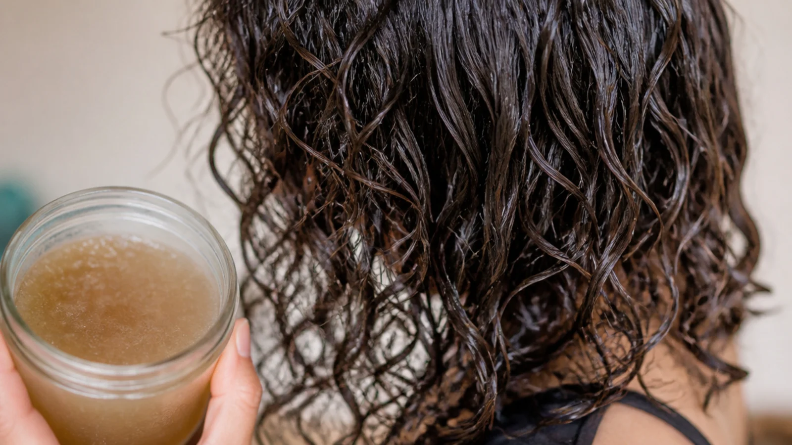 Homemade flaxseed gel in a jar used on soaking wet curly hair to stop in-the-curl frizz