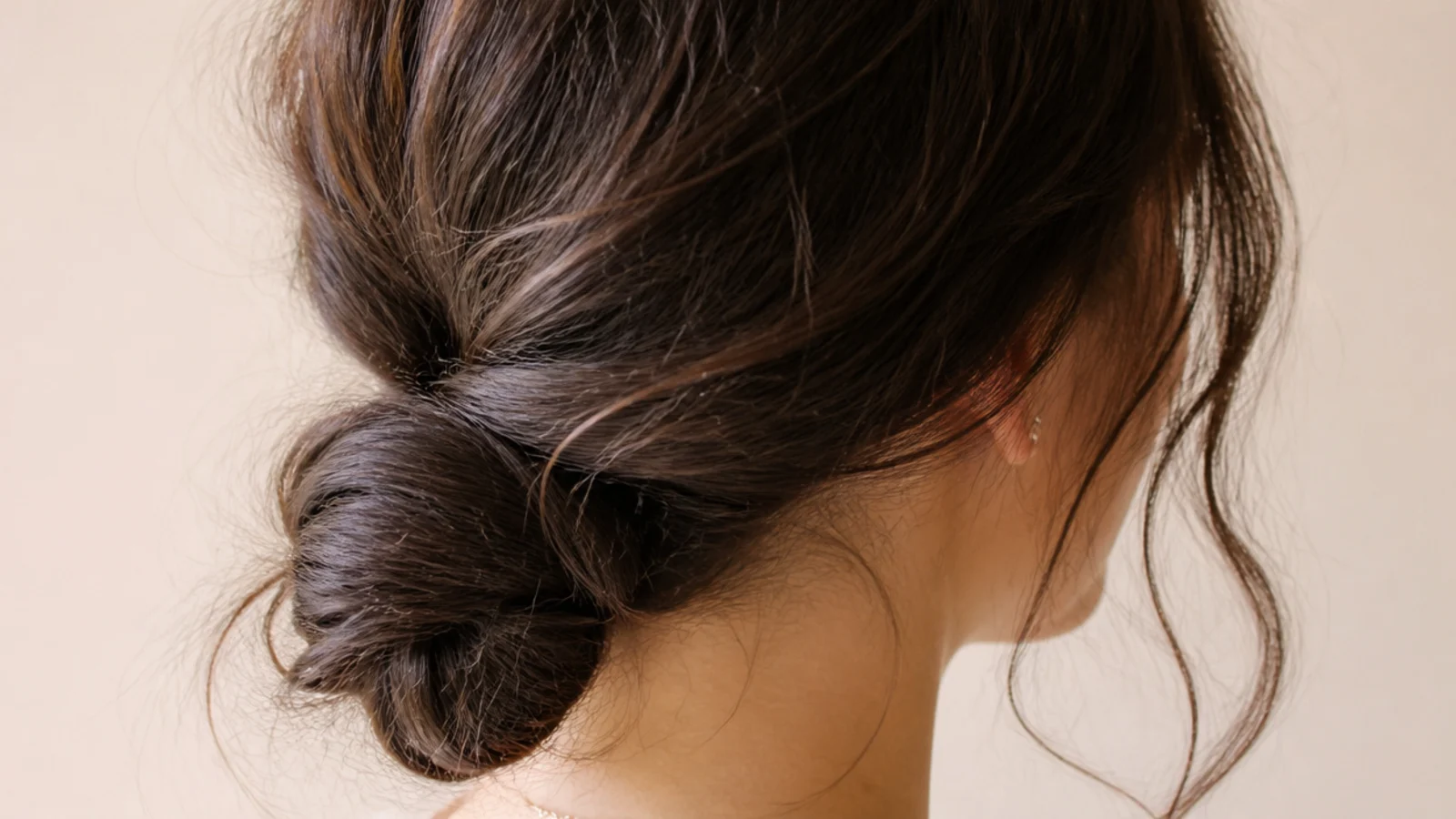 Low twisted bun at the nape on day three frizzy hair with two soft front pieces left loose