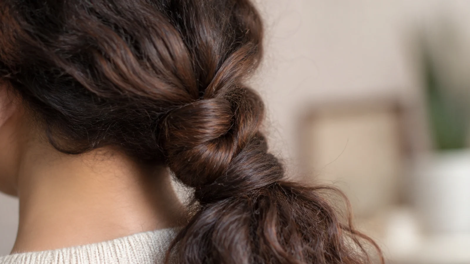 Frizzy hair in a rope twist ponytail made from two sections twisted and wrapped together