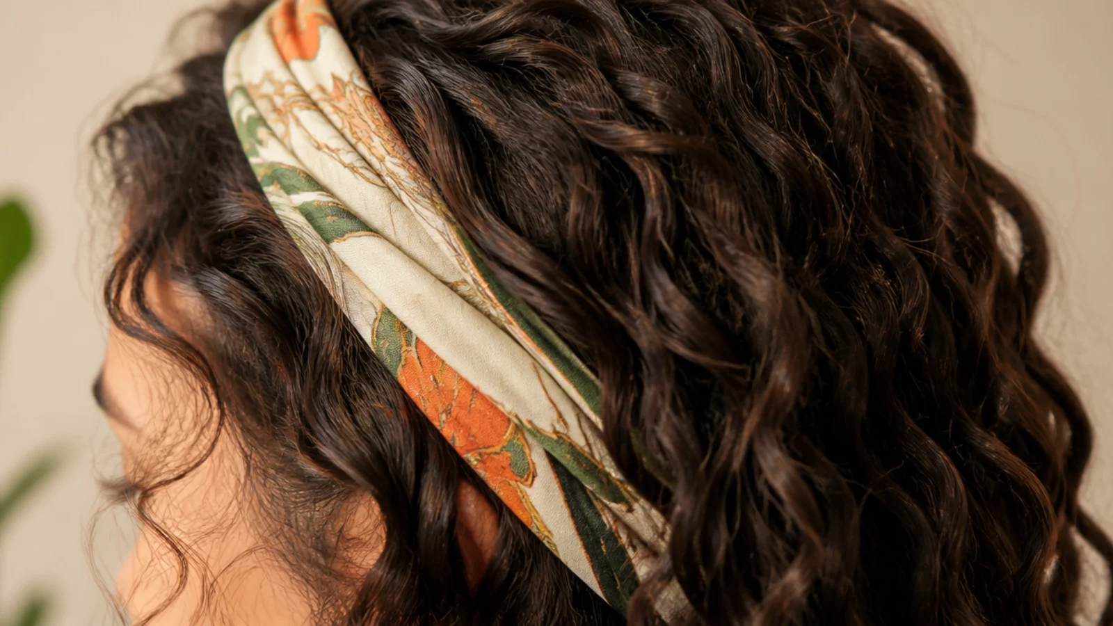 Patterned silk scarf tied as a headband over air-dried frizzy curly hair