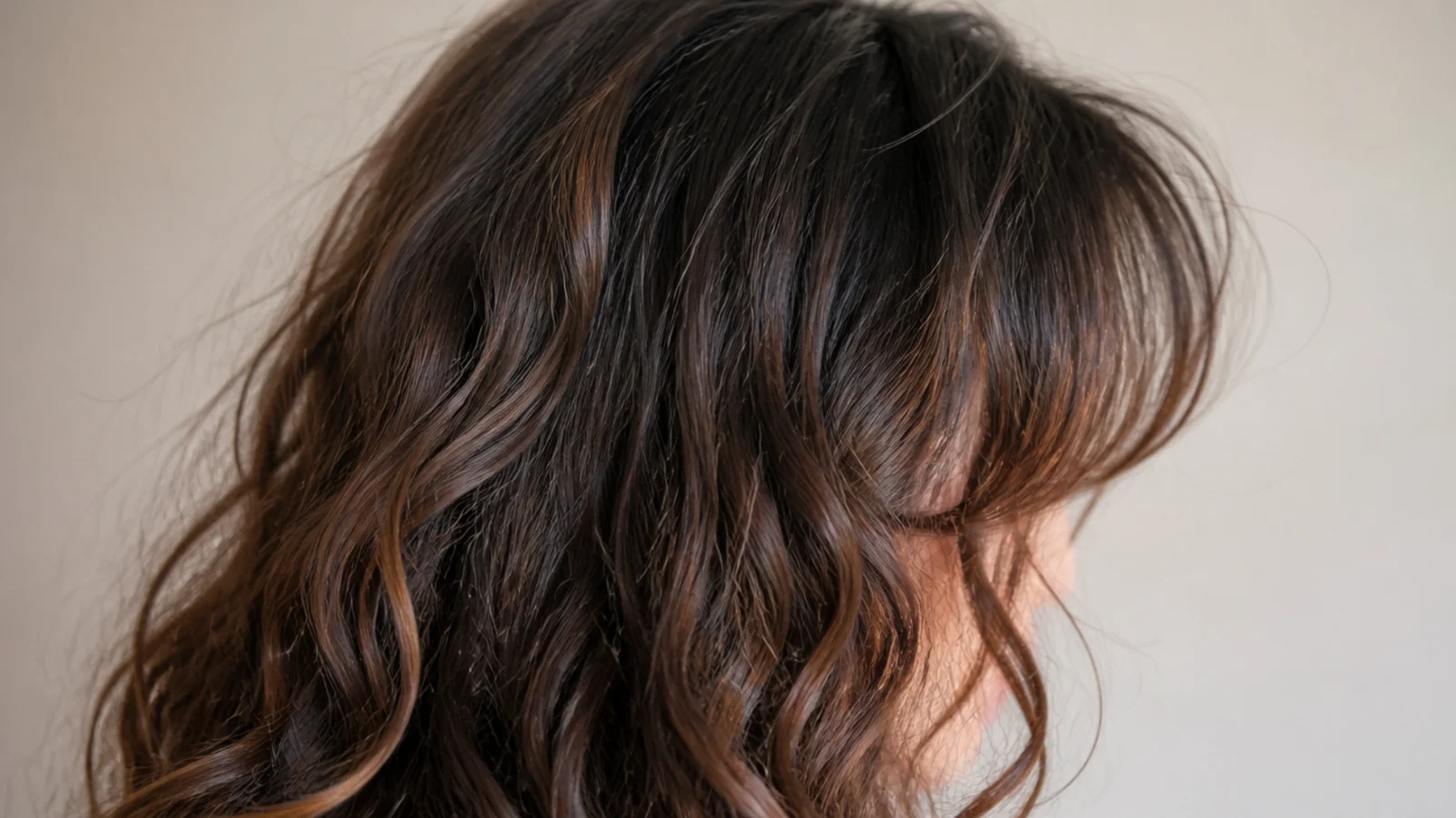 Air-dried frizzy hair with soft curtain bangs parted in the middle and swept away from the face