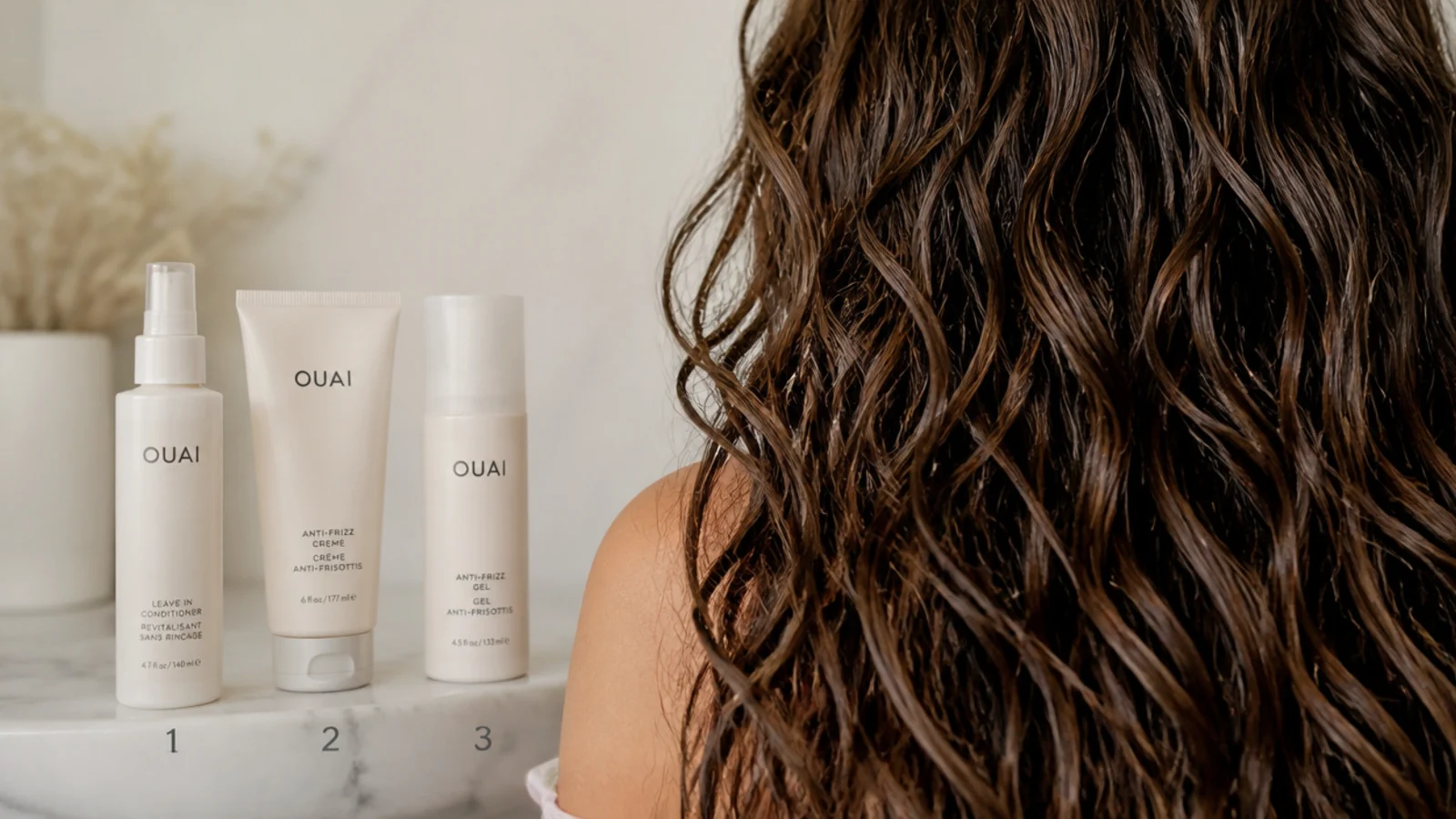 Three anti frizz products lined up in layering order, leave-in conditioner, styling cream and gel
