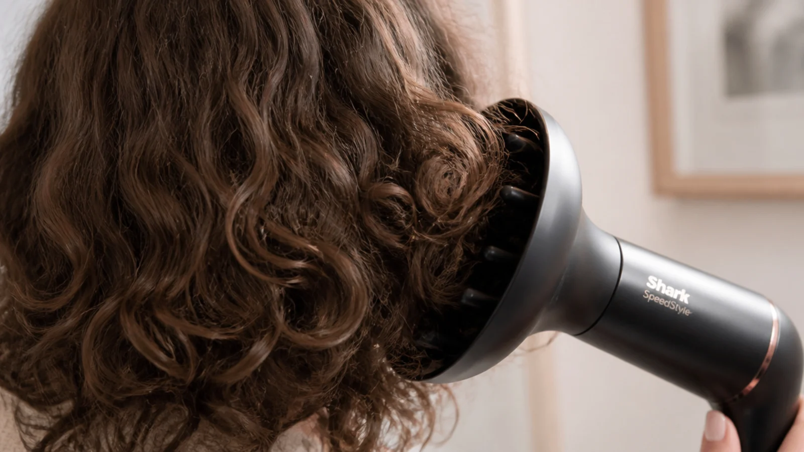 Diffuser attachment cupping curls of frizzy hair on low speed to dry without disturbing the curl pattern