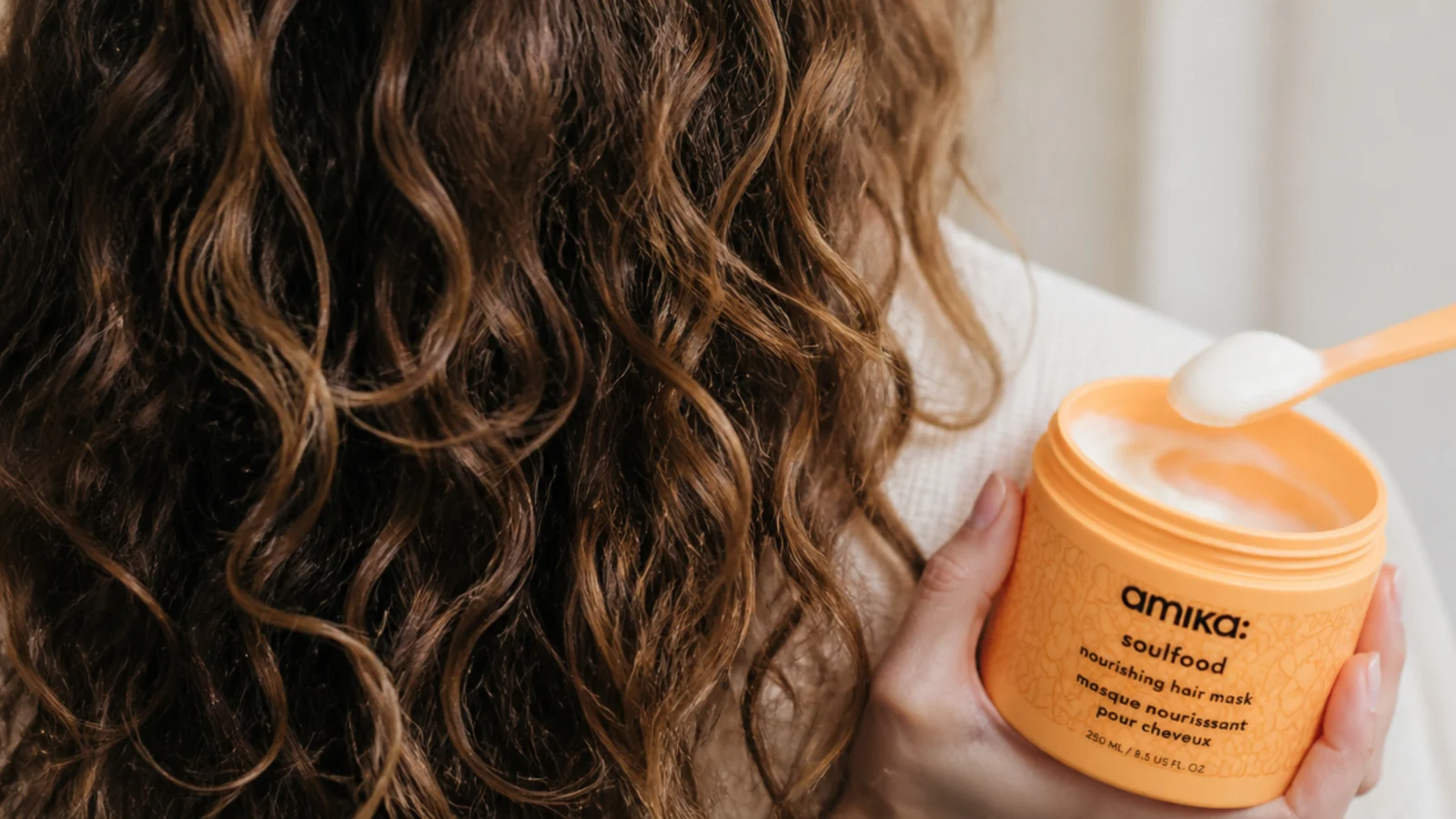 Amika Soulfood nourishing hair mask jar with a scoop of thick cream for frizzy hair