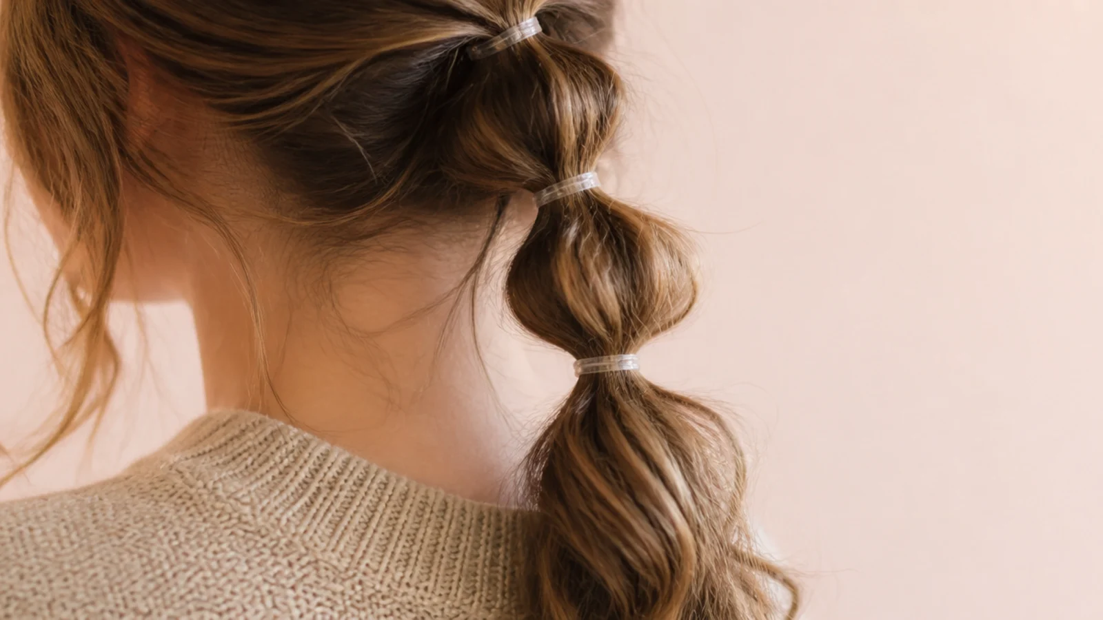 Bubble ponytail on second-day frizzy hair with four evenly spaced clear elastics down the length