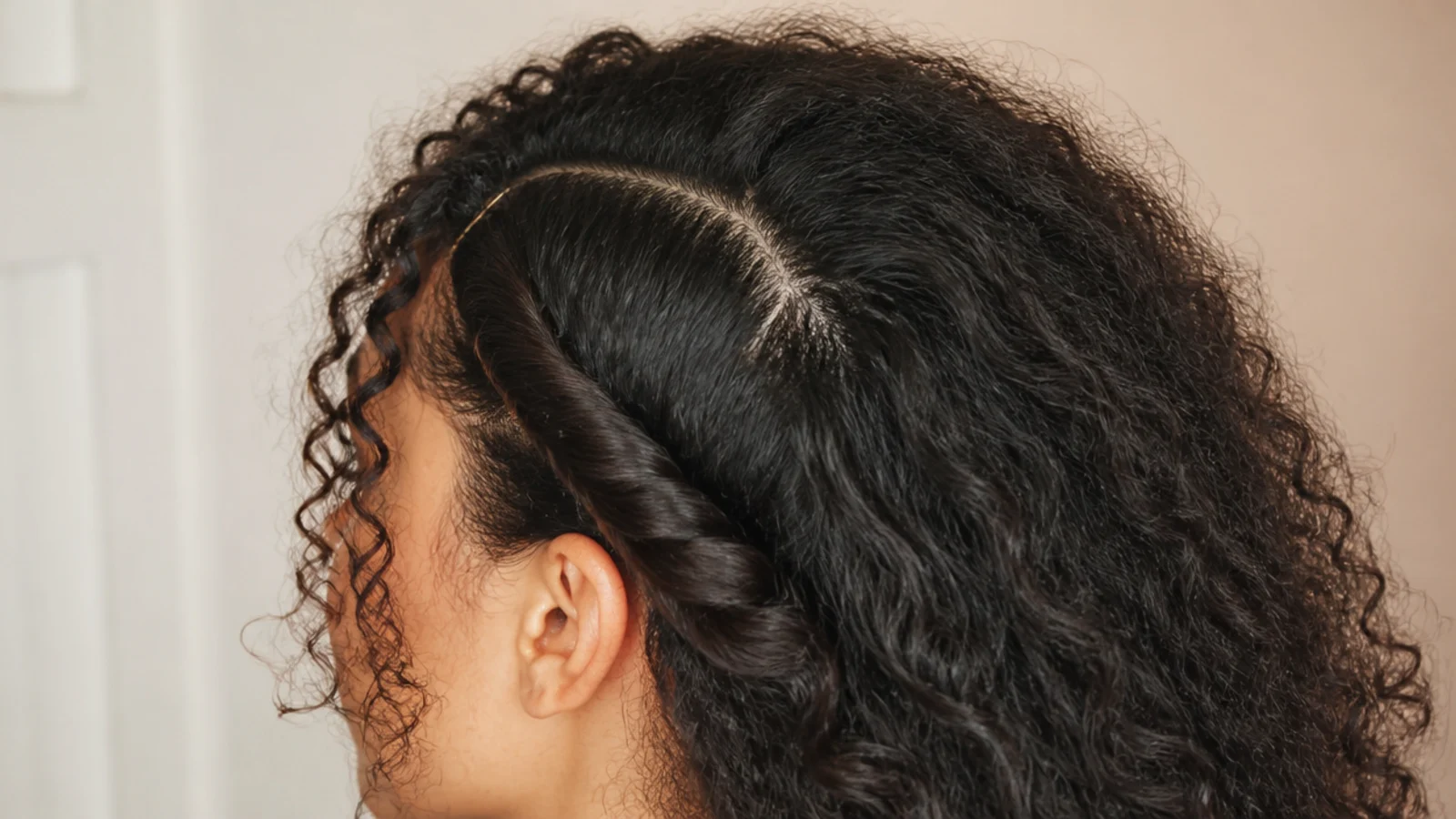 Deep side part on puffy frizzy hair with a two inch twisted section pinned behind one ear