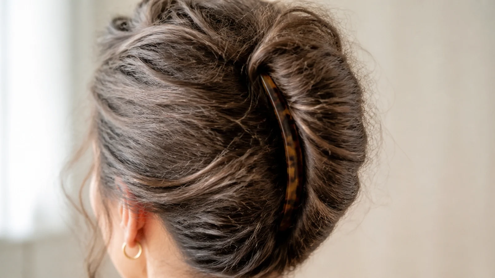 Vertical French twist on puffy frizzy hair pinned closed down the back of the head