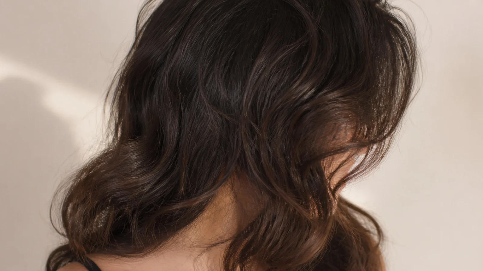 Curtain bangs on thick frizzy hair splitting at the center and blending into piecey face framing layers