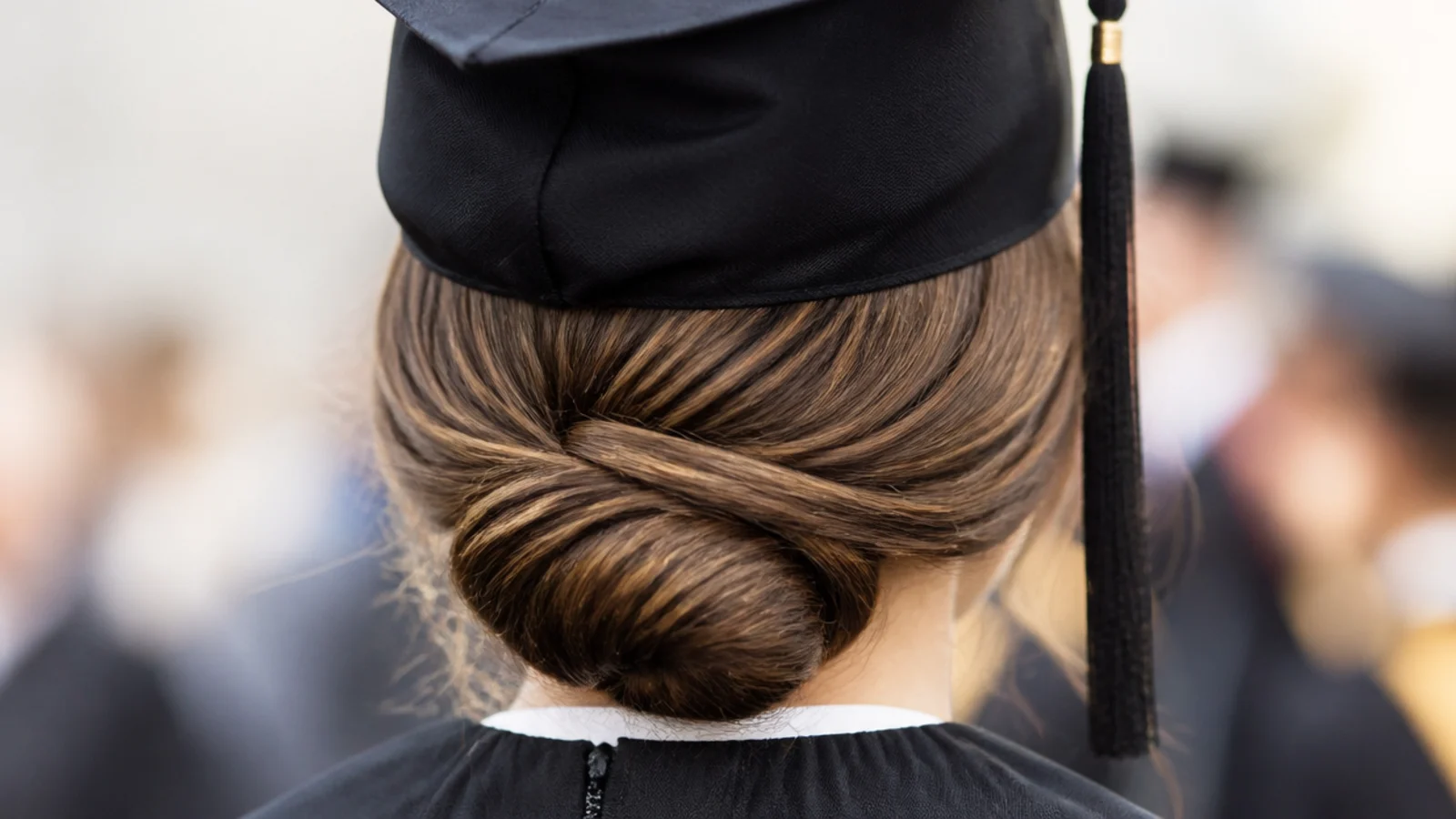 Low graduation chignon rolled at the nape and held with two spin pins under the cap