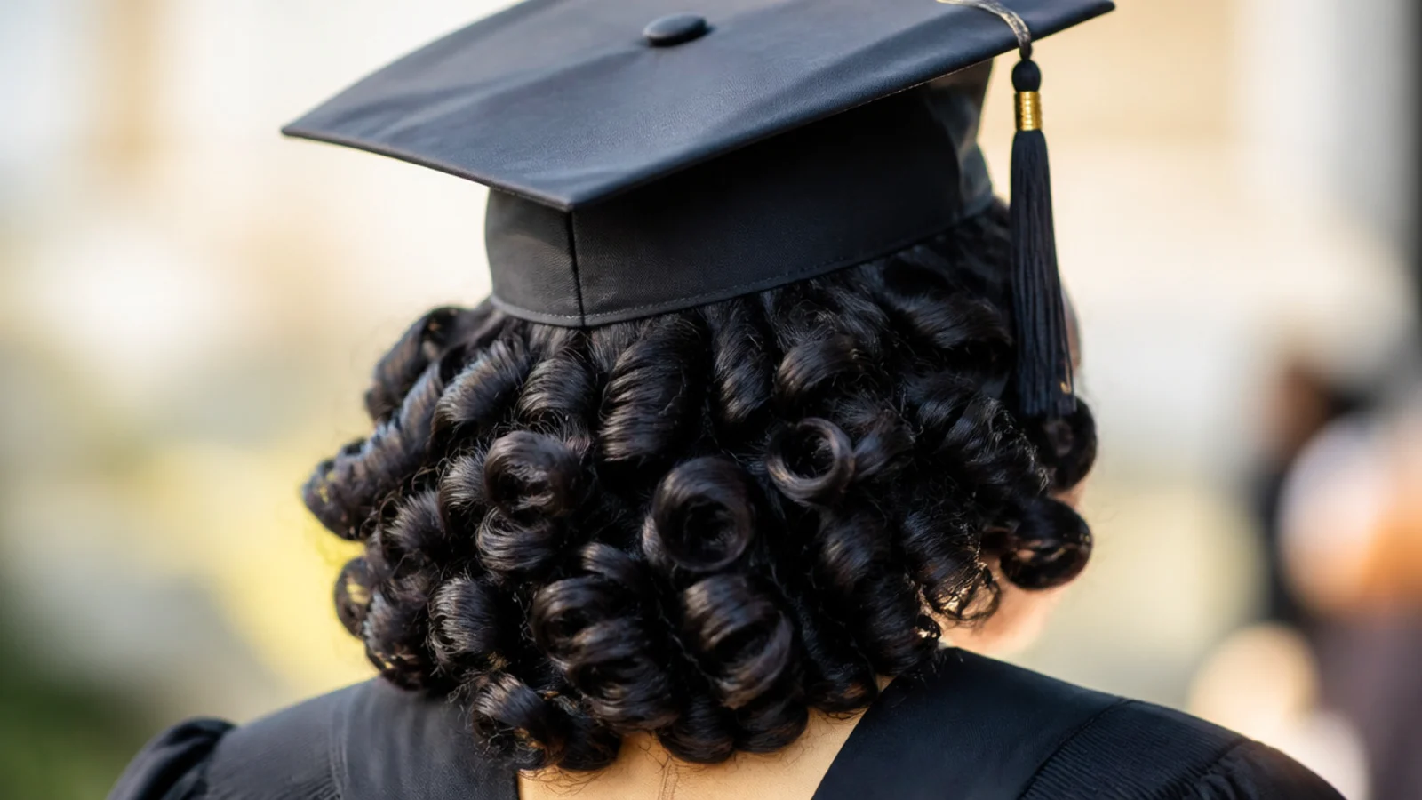 Flexi-rod set on 4B hair giving defined bouncy curls beneath a graduation cap