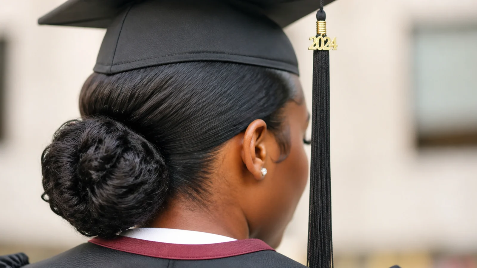 Sleek low bun on natural hair with laid edges and a graduation cap sitting flat on the crown
