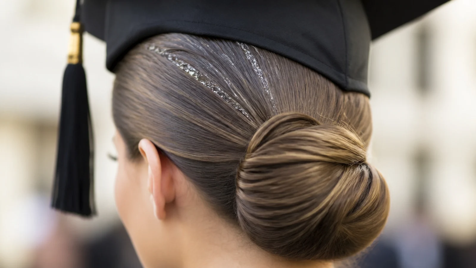 Slicked back low bun graduation hairstyle with gel showing white flaking along the part after four hours