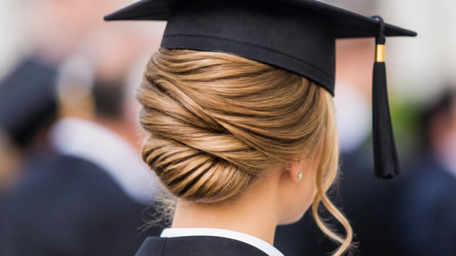 Classic French twist graduation updo pinned vertically down the back of the head under a mortarboard