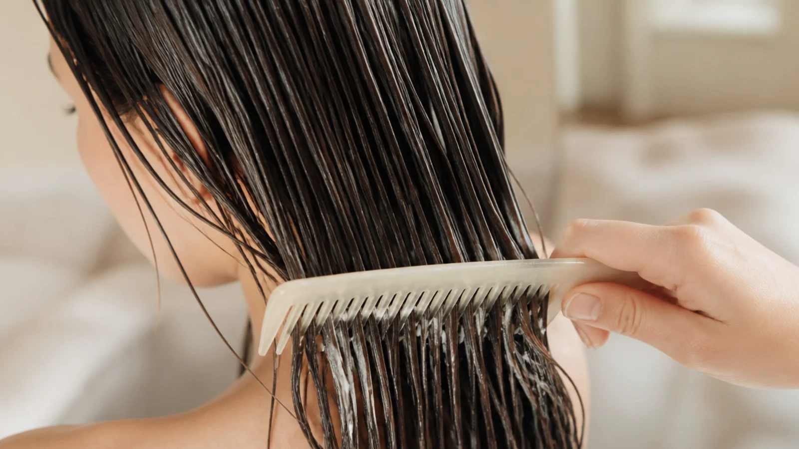 Wide tooth comb detangling conditioner-coated wet hair starting at the ends