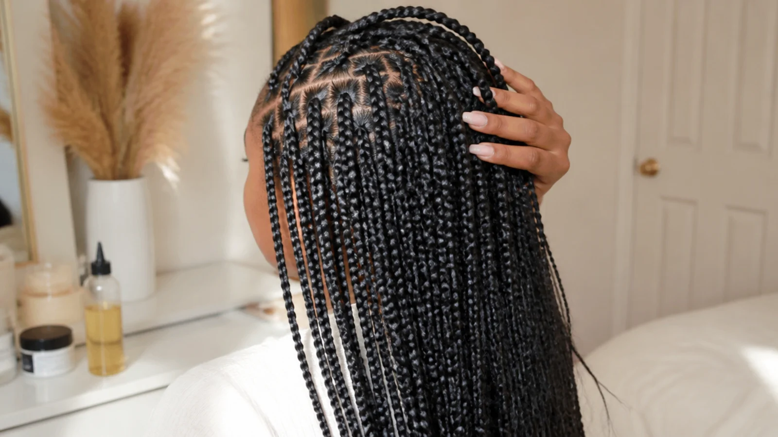 Knotless box braids on a Black woman with relaxed tension at the hairline and visible healthy edges