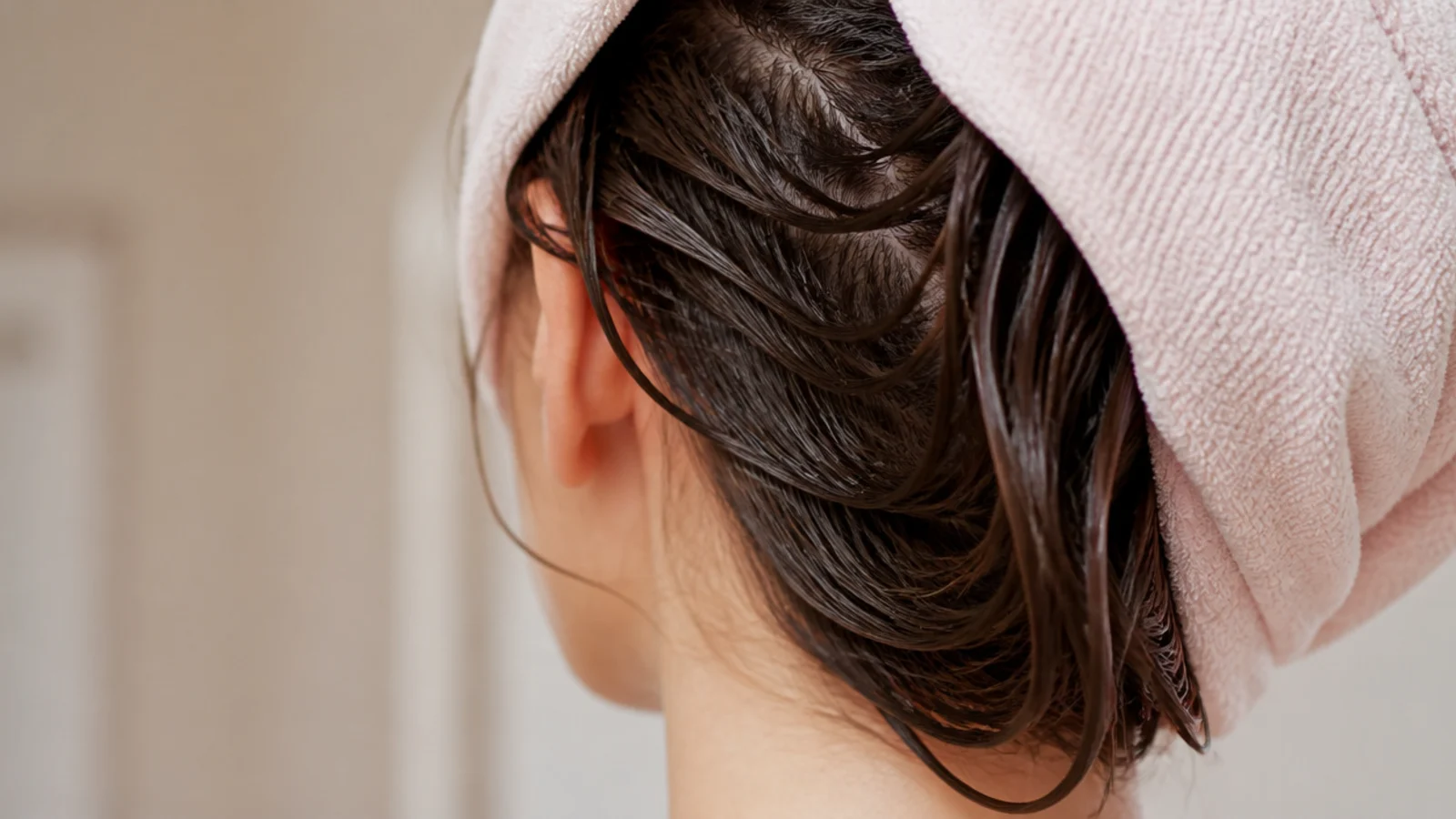 Long wet hair wrapped in a soft microfiber hair towel instead of a rough terry towel