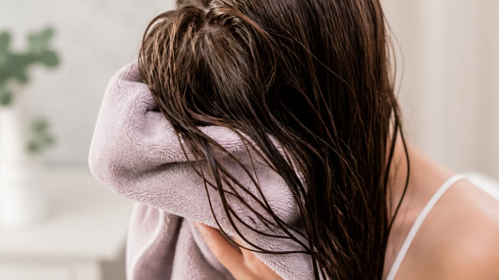 Long wet hair being squeezed gently inside a soft microfiber hair towel