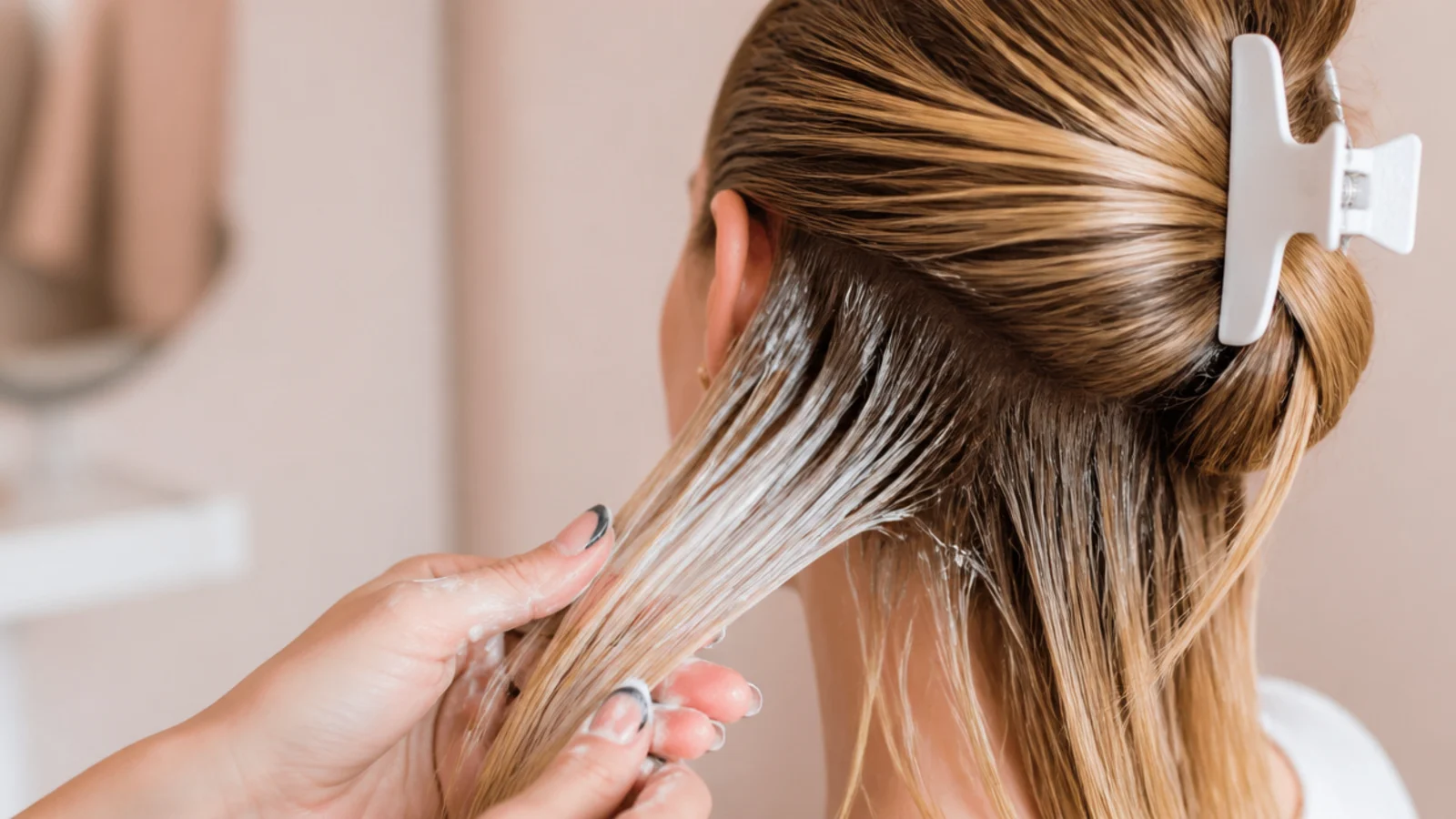 Bond building protein treatment being worked through bleached ends of long blonde hair