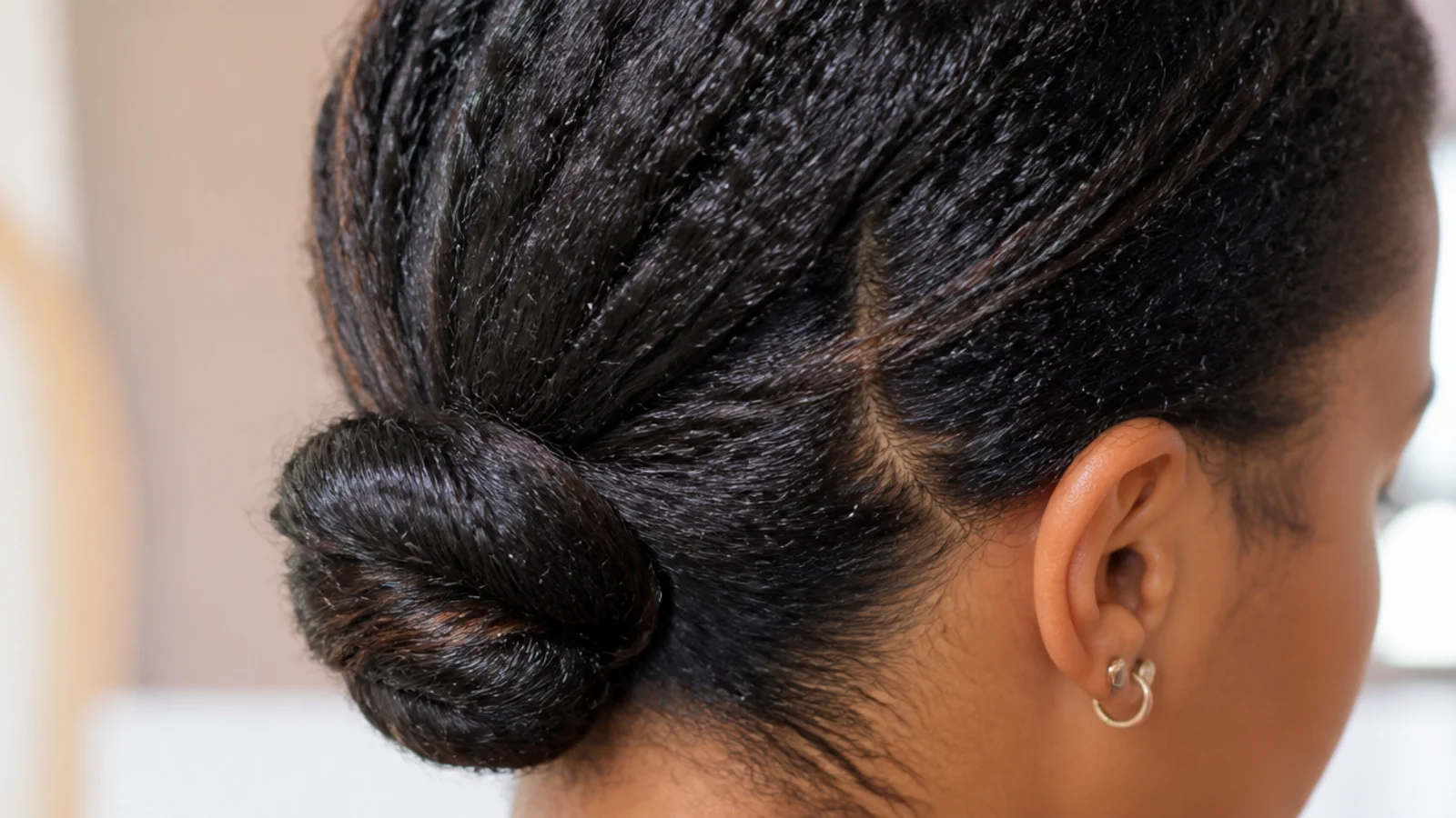 A low twisted bun protective style with the ends tucked away at the nape of the neck