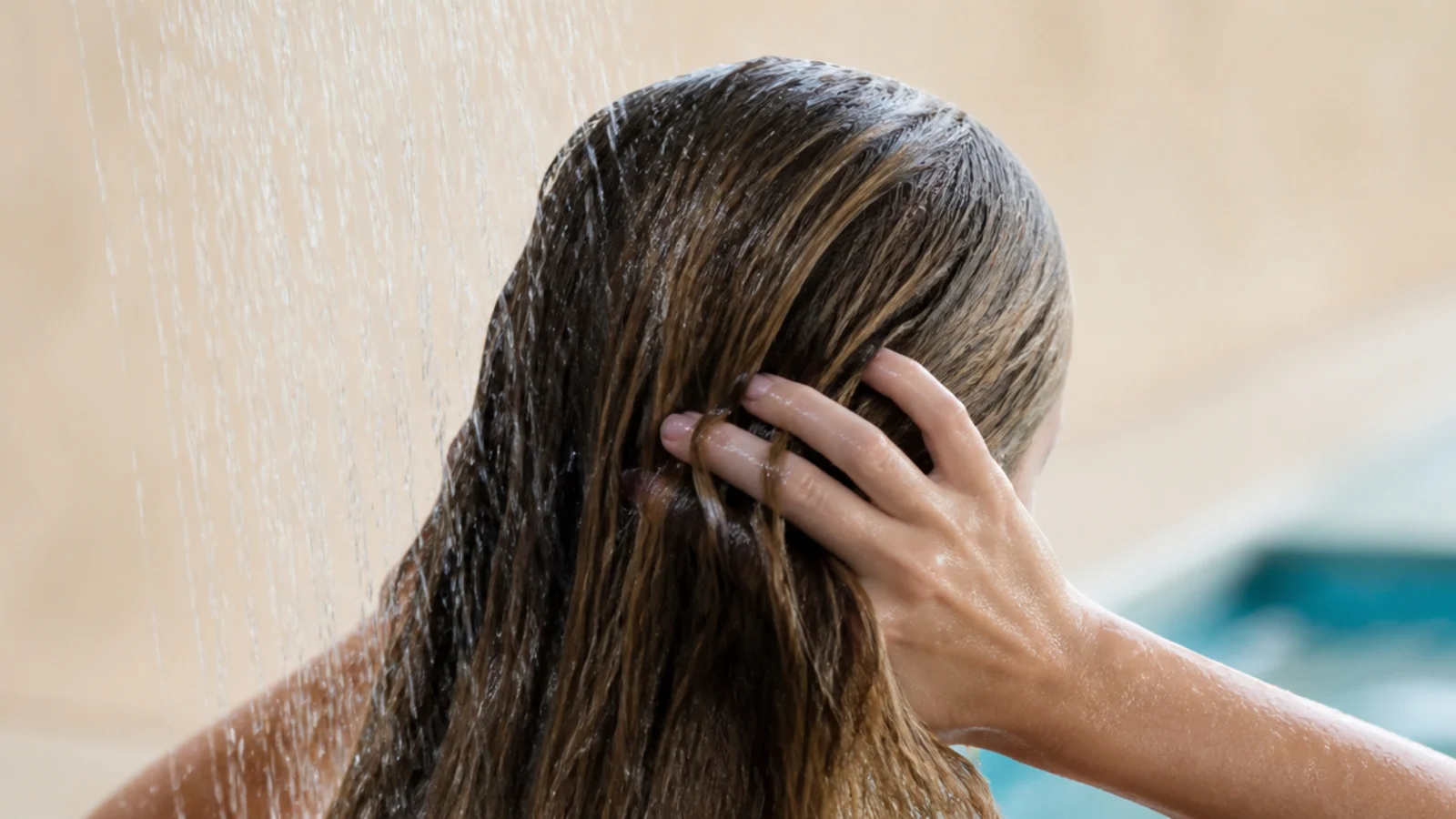 Hair being rinsed under a poolside shower immediately after swimming to remove chlorine