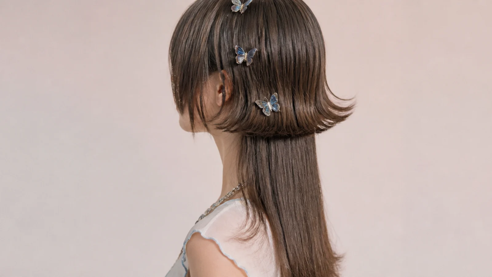 Y2K aesthetic jellyfish haircut with a flicked-out bell, butterfly clips and mid-back length hair