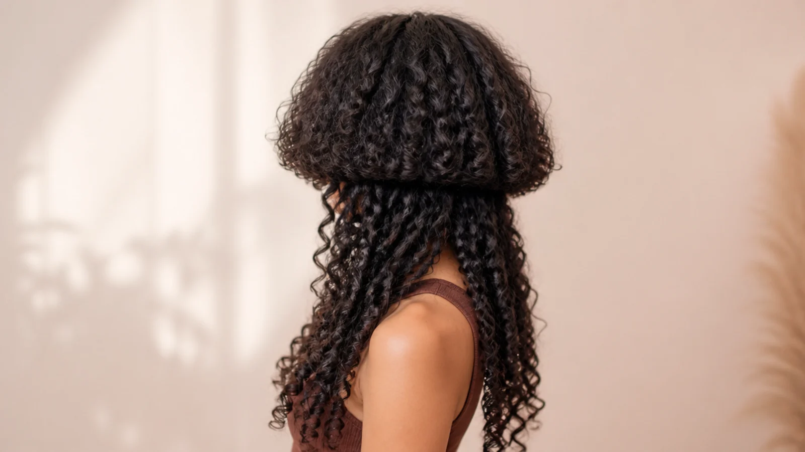 Curly jellyfish haircut on thick coarse hair with a heavily debulked bell above long dense curls