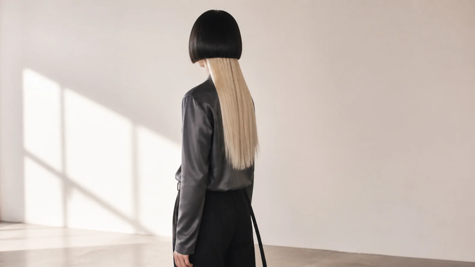 Edgy jellyfish haircut on a woman with a blunt cheekbone-length black bell over long straight platinum lengths