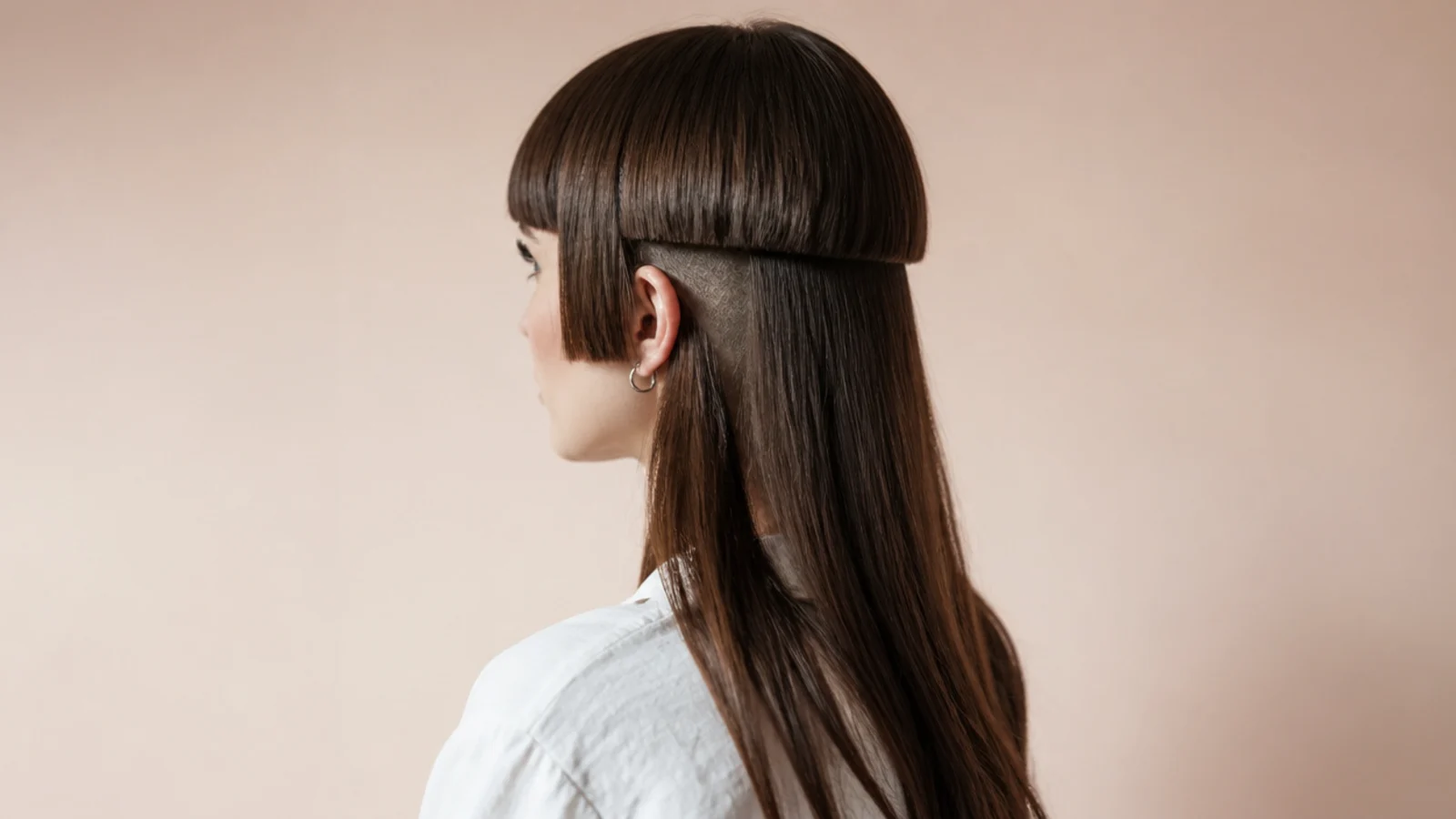 Jellyfish haircut with micro bangs and a hidden nape undercut revealed under the long lengths