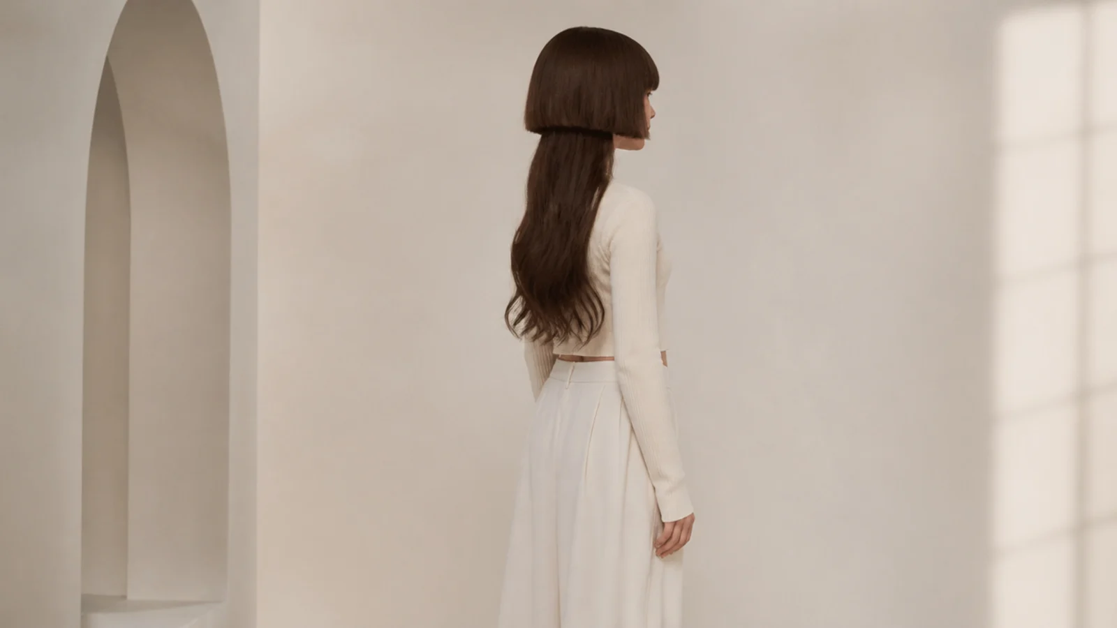 Wavy jellyfish haircut on a woman with a blunt cheekbone-length bell over long loose waves