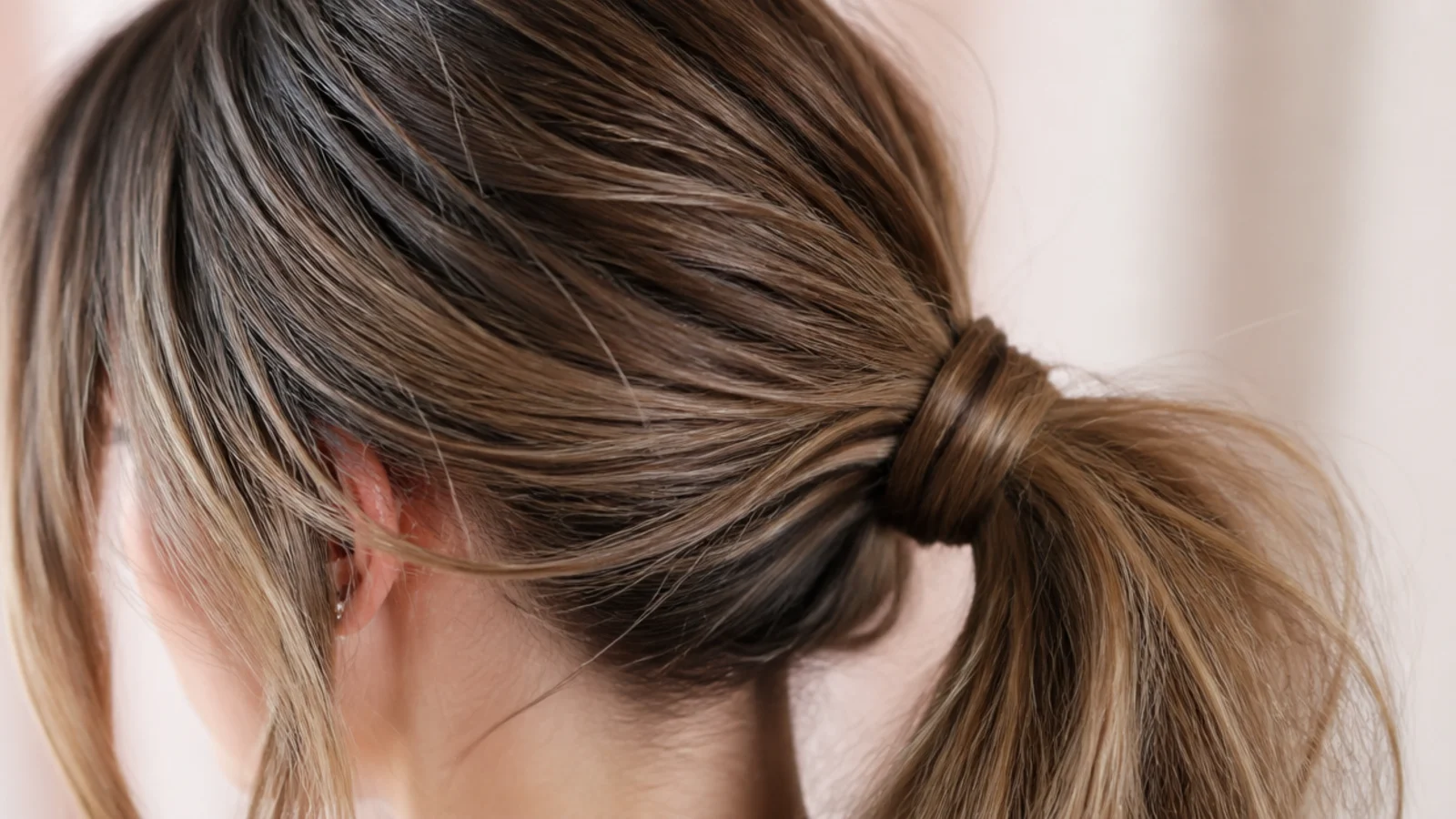 Messy ponytail on day three greasy hair with dry shampoo worked into the roots for grip