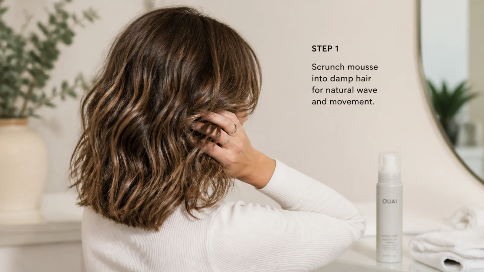 Styling a wavy mid length haircut by scrunching mousse into damp hair and air drying