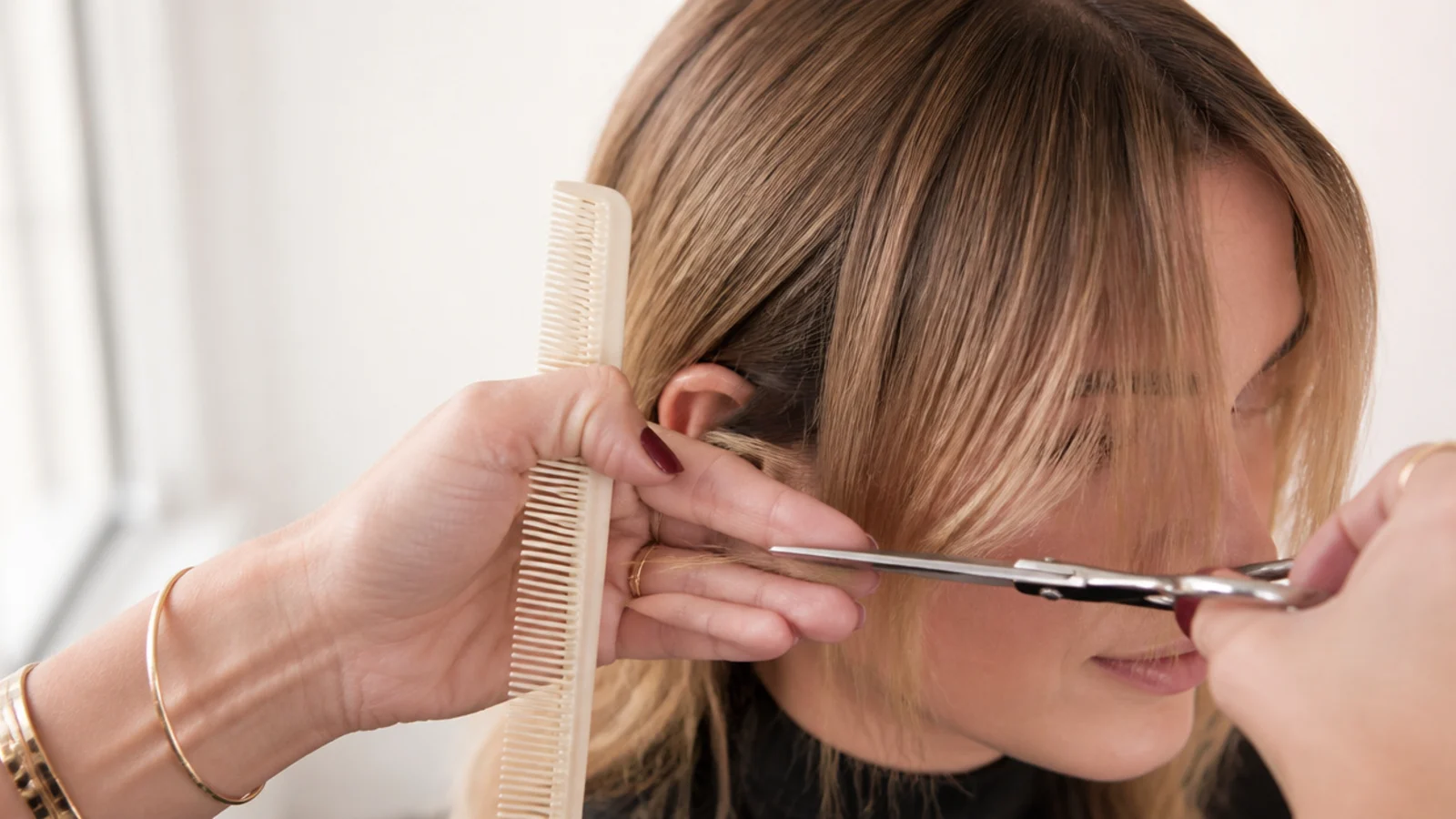 First conservative point cut into a short curtain bang guide strand left long on purpose