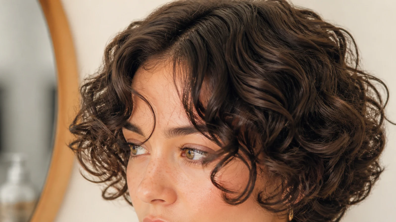 Curly short curtain bangs with defined ringlets framing a round face