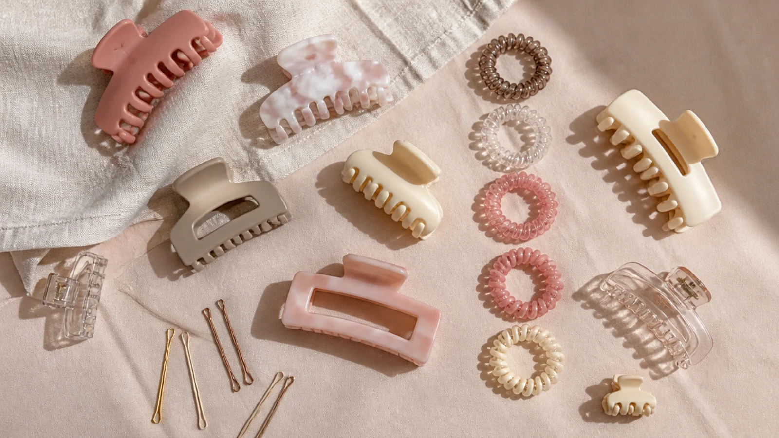 Faceless overhead view of different sized claw clips, spiral elastics and bobby pins laid out