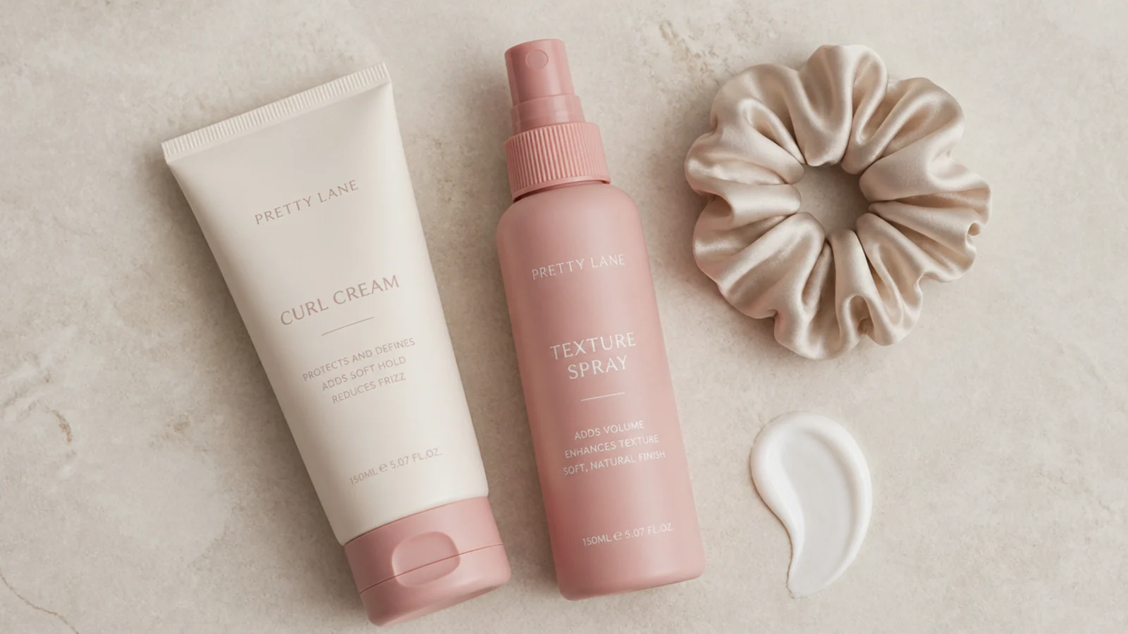 Faceless flat lay of curl cream, texture spray and a scrunch of product for heatless trend styling