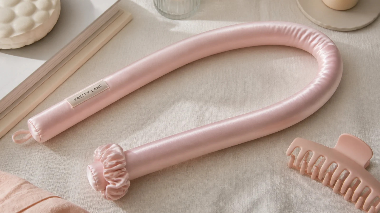 Faceless flat lay of a long padded satin heatless curling rod for overnight waves